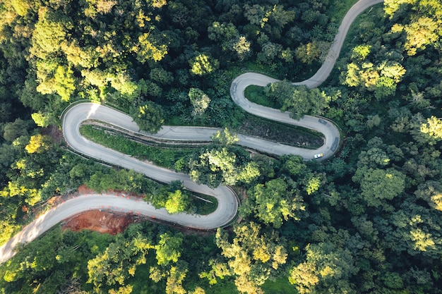 曲がりくねった山道を旅する木々に囲まれた曲がりくねった道の航空写真