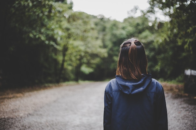 Traveling woman on road in the forest,Travel Concept.