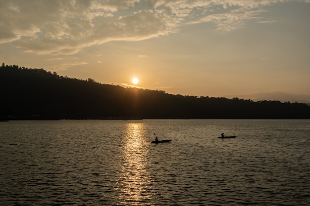 Viaggiatore in canoa sul lago durante il tramonto.