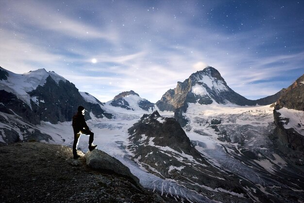 スイスアルプスの山々で素晴らしい星空の夜を楽しむ旅行者