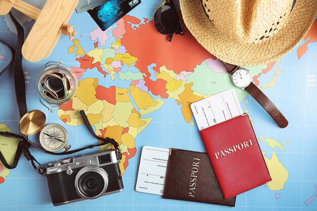 Traveller's accessories on world map background top view Travel planning concept