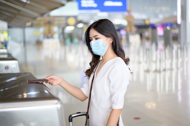 여행자 여성이 국제 공항에서 보호 마스크를 쓰고 코로나 19 유행에 걸렸고,