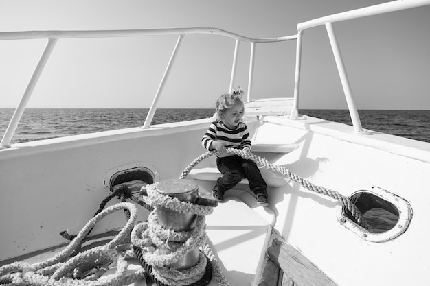 여행 개념 어린 아이는 배를 타고 여행을 즐깁니다. 바다로 여행하는 아기 소년 여름 방학에 여행 바다와 하늘 사이