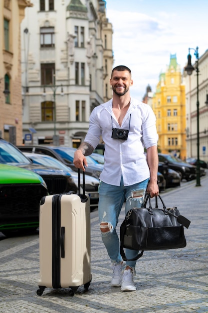 Путешествующий концепт-человек-путешественник с дорожной сумкой на открытом воздухе портрет молодого кавказца в рубашке на