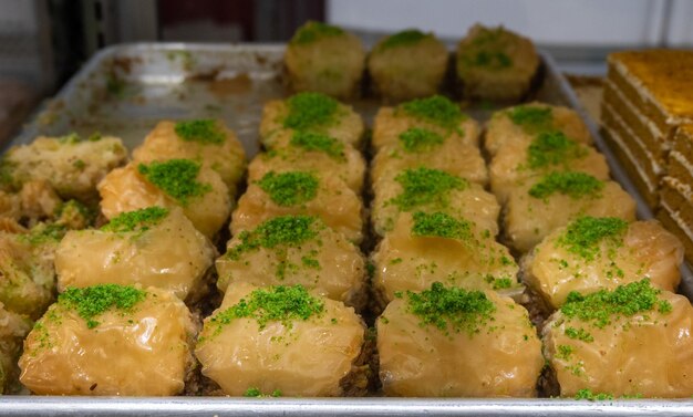 A tray of baklava with green sprinkles on top