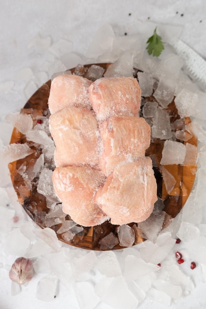 A tray of frozen salmon fillets with ice on a table.