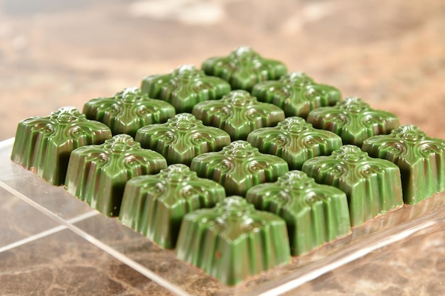 A tray of green mochi on a marble surface