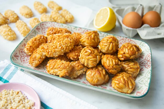 A tray of japanese fried rice cakes with a plate of cookies on the side.