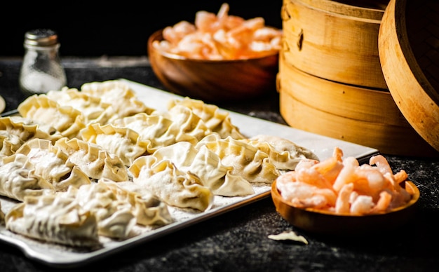 Photo a tray of meringue is next to a bowl of shrimp.