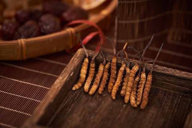 A tray of organic root vegetables with a basket of figs in the background.