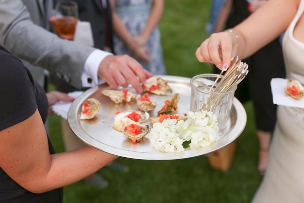 A tray of oysters is being served at a wedding.