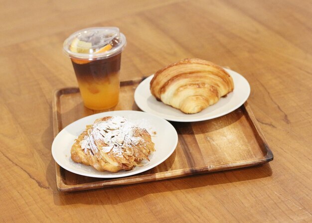 a tray of pastries and a cup of beer on a wooden table