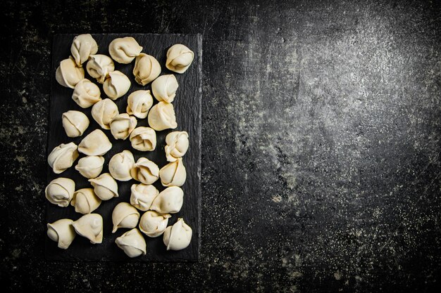 A tray of ravioli on a black background