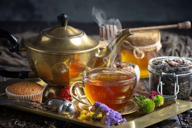 A tray of tea with a gold teapot and a cup of tea on it.