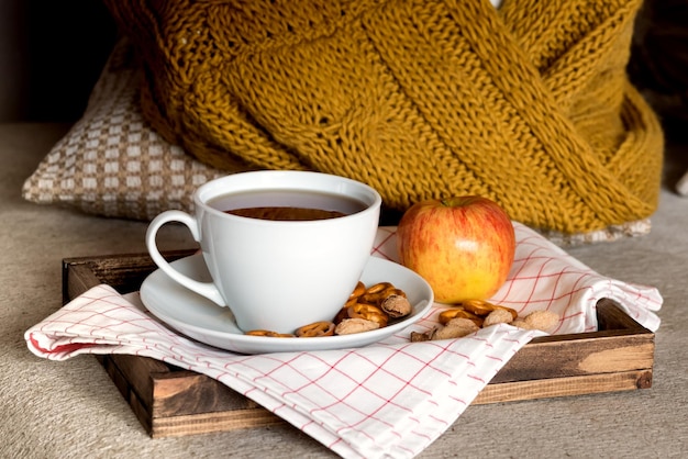 Tray with autumn breakfast Morning warm and cozy concept Cup of tea nuts crackers and apple