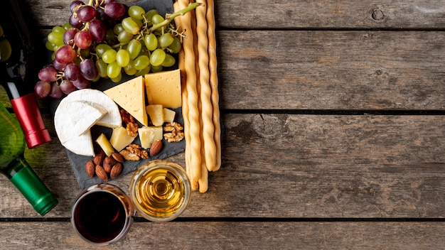 Photo tray with cheese and grapes beside wine bottle