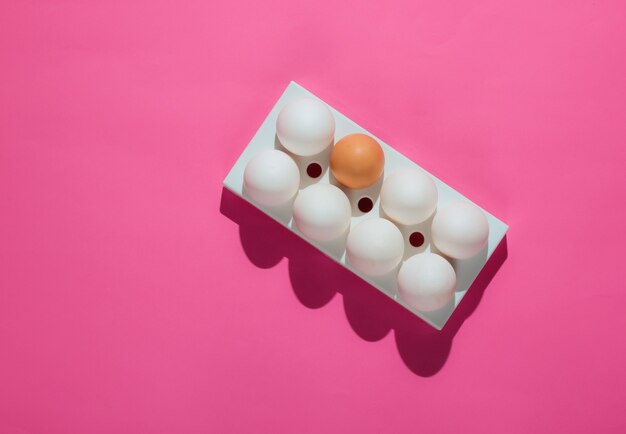 Tray with chicken eggs on pink.