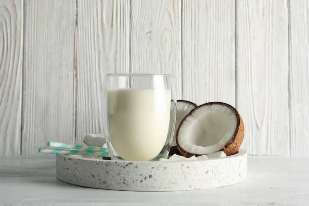 Tray with coconut and milk on wooden table. Tropical fruit