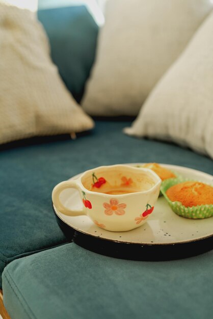 A tray with a cup of coffee and cupcakes