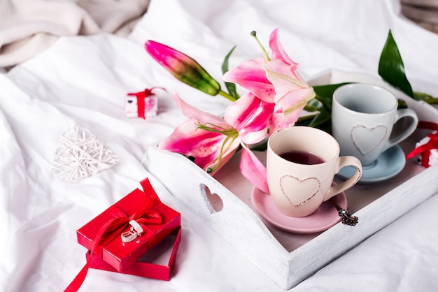 tray with cup of hot tea in the bed,