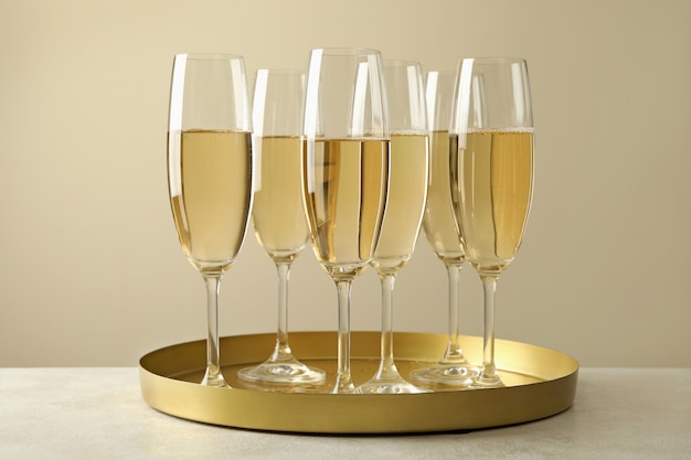 Tray with glasses of champagne on white table