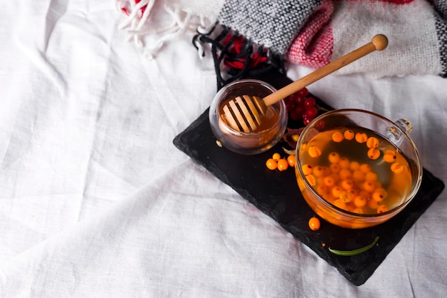 Tray with honey and a cup of hot tea in the bed,