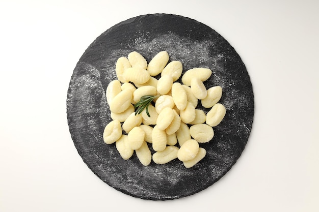 Tray with raw potato gnocchi on white background