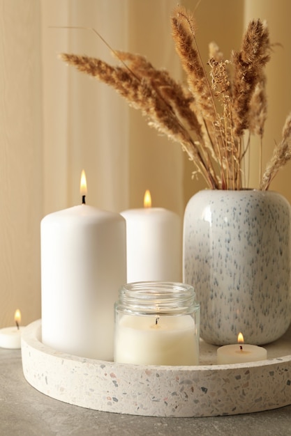 Tray with scented candles and reed on gray table