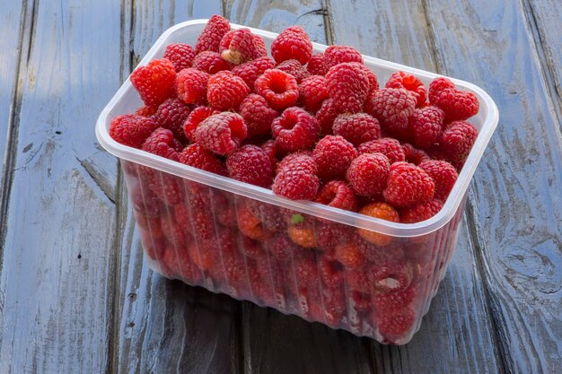 Trays with raspberries on a wooden background