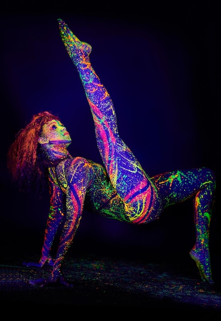 Treasures in the dark Full length shot of a young woman posing with neon paint on her face