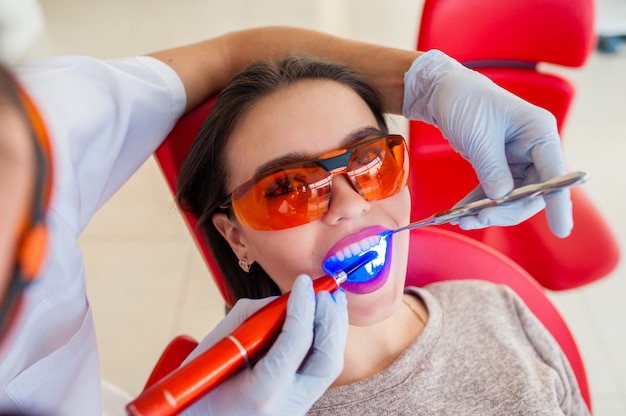 Treatment of light seal beautiful girl in dentistry.