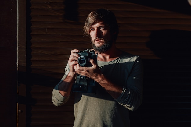 Tredny young man with camera in his hands