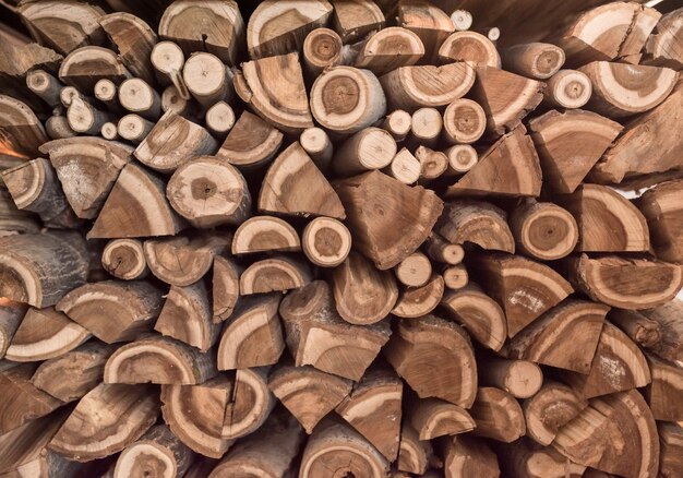 Tree. Background with stacked wooden logs. Preparation of firewood for the winter. Texture.