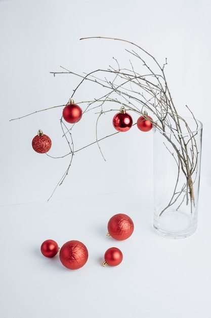 Tree branhes in vase decorated with red ornaments Christmas composition White background Vertical