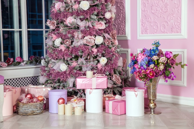 tree decorated in pink toys. Christmas with presents in room interior