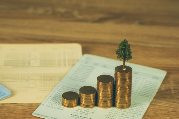 Photo tree growing on pile of golden coins and account book