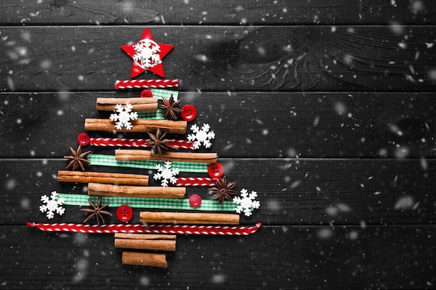 Foto albero fatto di decorazioni natalizie su sfondo scuro in legno carta di capodanno