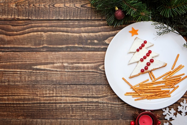  Tree made from bread with cream cheese decorated with berries on a white plate 