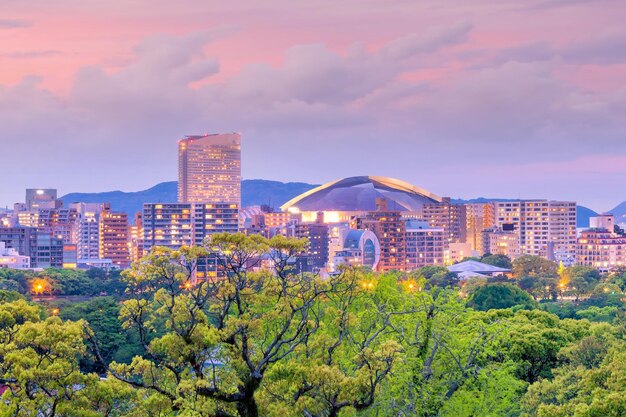 写真 夕暮れの空に照らされた木や建物