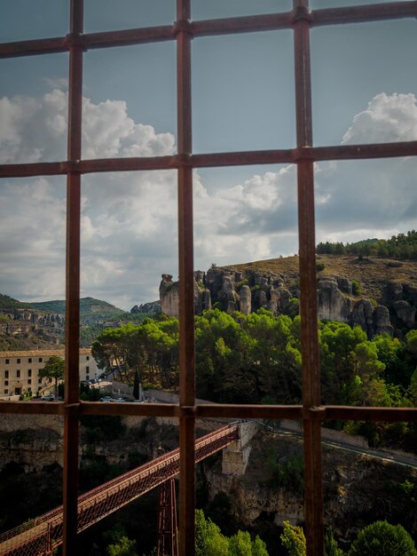 Foto alberi e edifici contro il cielo visti attraverso la finestra casas colgadas cuenca