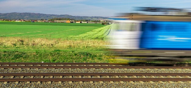 Foto trein op spoor in het midden van het veld tegen de lucht