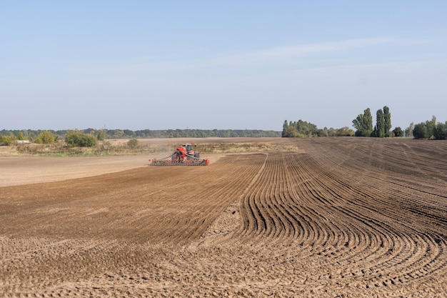 Foto trekker die grond bewerkt en een veld gereedmaakt voor beplanting