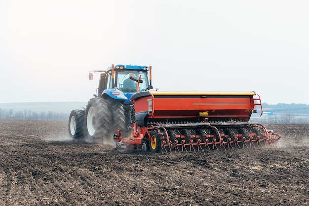 Trekker op het veld landbouw in het dorp en dorp zaaien in de lente agronoom op een combinexA