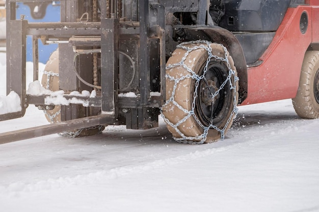 Trekkerwiel met kettingtrekker of lader op een gladde besneeuwde wegladers rijden op sneeuw met antis