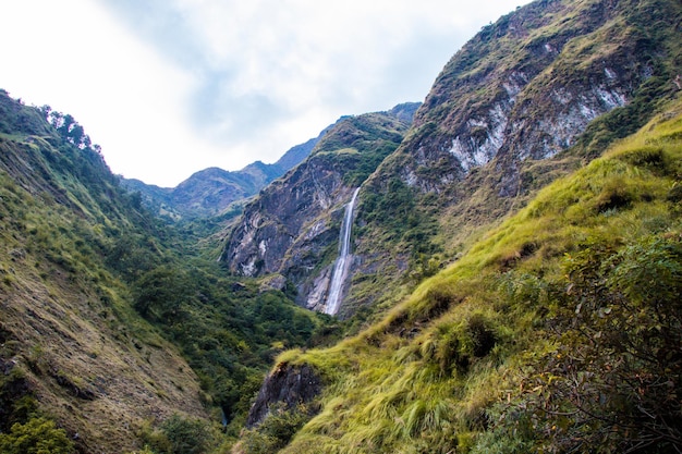 Trekking in de Himalaya-bergen van Nepal met prachtige groene heuvels, rivier en watervallen