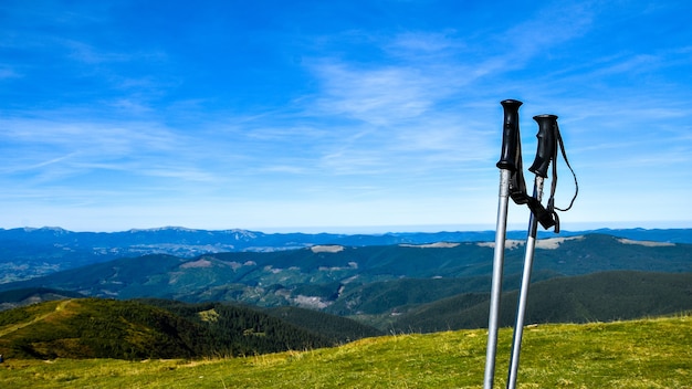 秋の山々の美しい景色を望む山頂のトレッキングポール。自然な背景。ハイキング。旅行の目標の概念