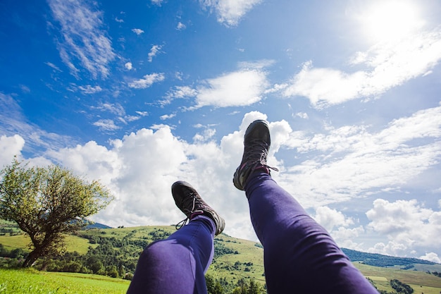 Trekking shoes on the legs over idyllic landscape