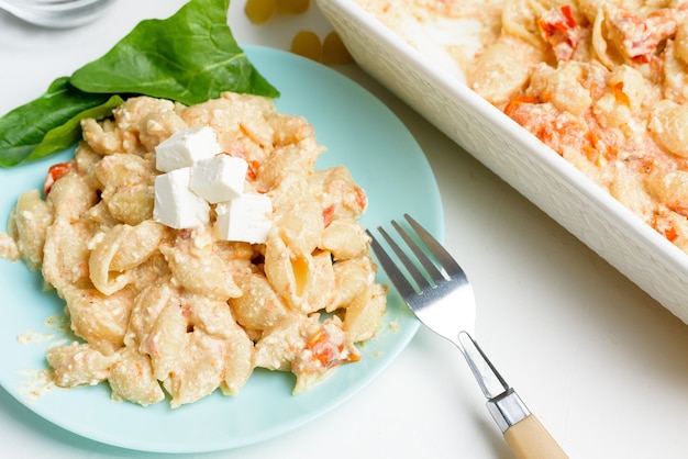 Trend oven-baked feta cheese with tomatoes and pasta, pepper garlic top view, mixing macaroni and cheese.