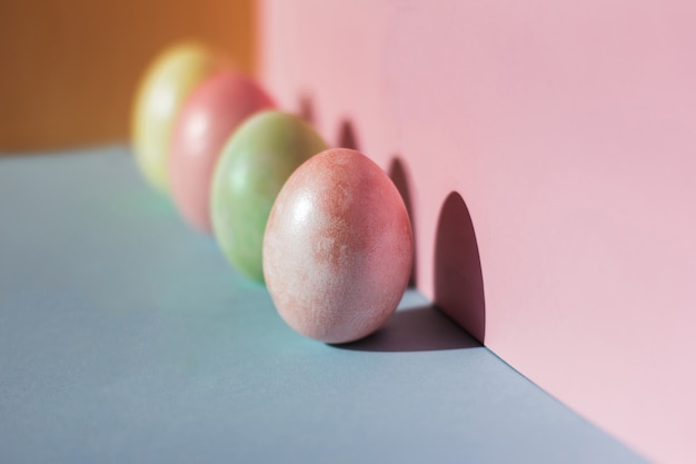 Trend pastel colorful Easter eggs on pink and blue background Copy space for text