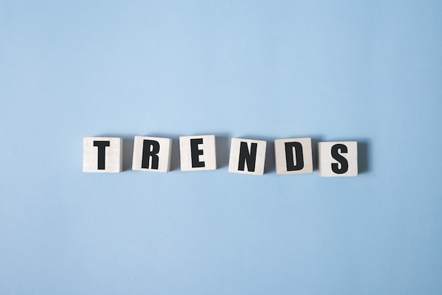 Trend word on cube blocks isolated on blue